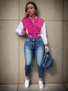 Detail view of pink and white varsity jacket with striped cuffs and snap buttons.