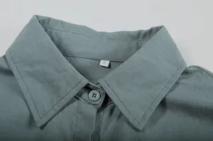 Close-up detail showing the lapel collar and button of a casual solid color long sleeve shirt