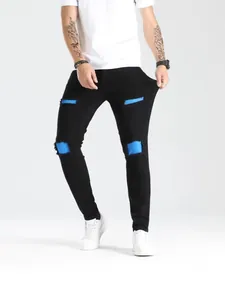 Jeans skinny strappati da uomo neri con dettagli patch blu e denim elasticizzato alla moda