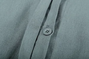 Close-up of a button and linen-like texture on a grey long-sleeve casual shirt