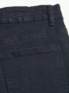 Close-up of black denim jeans back pocket detail with reinforced stitching