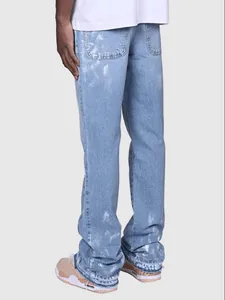 Detail view of men's light blue distressed straight leg denim jeans with frayed hem