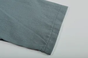 Macro view of high-quality stitching detail on teal linen fabric women's garment sleeve