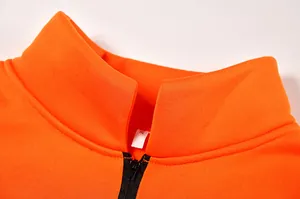Primo piano del colletto di una felpa arancione con mezza zip e taglia