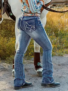Vista detallada de vaqueros azules ajustados estilo western con bordado de caballo