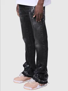 Detail view of men's distressed black straight-leg denim jeans with unique frayed hem
