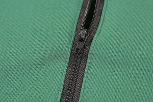 Dettaglio ravvicinato della cerniera nera su tessuto di felpa a maglia verde
