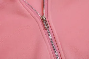 Macro view showing the sturdy silver metal zipper detail on a soft pink fleece hoodie.