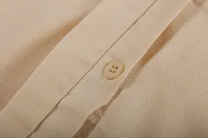 Close-up view of the fine texture and button detail on a beige linen-blend shirt