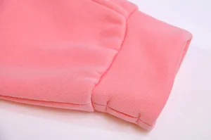 Close-up of pink fleece sweatshirt ribbed cuff featuring functional thumbhole detail