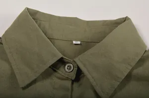 Close-up detail of olive green shirt collar with button and size S tag
