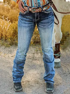 Primer plano de vaqueros bordados ajustados para mujer con costuras estilo western