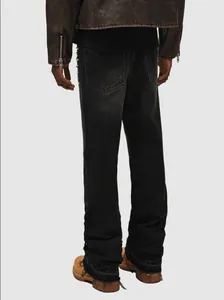 Back view of men's distressed black stacked denim jeans with raw hem streetwear style