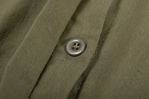 Macro detail of olive green linen fabric texture and button on casual shirt