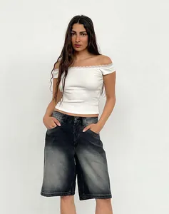 Model wearing vintage faded black loose denim shorts with white off-shoulder top
