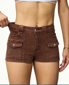Dettaglio di pantaloncini cargo in denim marrone a vita alta con tessuto elastico.