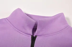Dettaglio ravvicinato di felpa viola con mezza zip che mostra colletto e trama