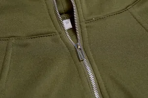 Detailed view of silver metal zipper and soft fleece on olive green cropped hoodie