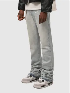 Detail view of light blue stacked jeans with white pearl accents and distressed hem detail