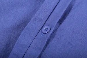 Macro detail of a blue linen shirt showing the fabric texture and button closure
