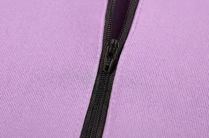Primo piano dettagliato di una cerniera nera su una felpa sportiva di colore viola.