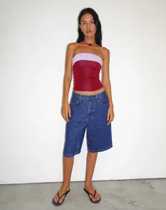 Full body view of female model in loose vintage blue denim shorts and red tube top
