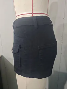 Vista dettagliata della gonna in denim elasticizzato nero con tasca laterale e bottone