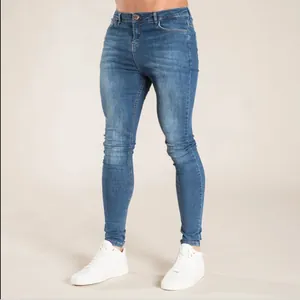Jean skinny bleu pour homme à coupe ajustée, porté avec de jolies baskets blanches.