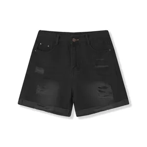 Detailed view of distressed ripped texture and rolled hem on black women's denim shorts
