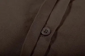 Close-up macro view showing the brown button and fabric texture on a casual linen shirt