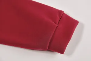 Dettaglio ravvicinato del polsino a coste di una felpa pullover rossa casual a maniche lunghe.