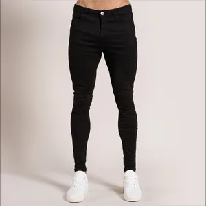 Vue de face d'un jean skinny noir coupe ajustée pour homme avec des baskets blanches