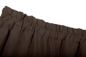 Macro view showing the elastic waistband detail of dark brown wide-leg trousers
