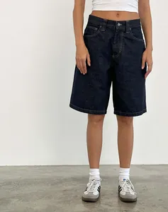 Retro loose fit dark blue denim mid-length shorts for women in minimalist studio setting