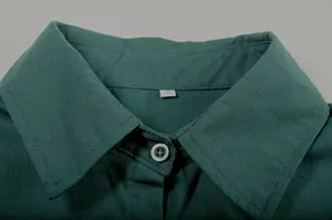 Close-up view of a green linen shirt collar with a size S tag and button detail.