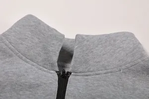 Primo piano del colletto con mezza zip di una felpa sportiva grigia casual da donna