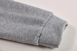 Dettaglio del polsino a coste elasticizzato e del tessuto grigio melange di una felpa da donna