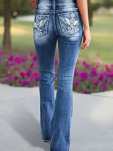 Back view of women's blue washed flare jeans with embroidered pocket details