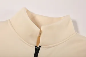 Dettaglio del colletto e della cerniera di una felpa pullover color crema da donna