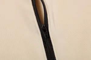 Dettaglio ravvicinato di una cerniera nera su un tessuto di felpa casual color crema morbido