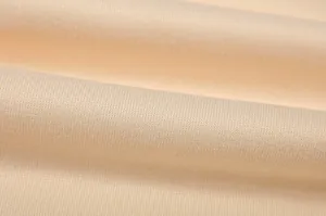 Vista macro della trama del tessuto a maglia color crema per una felpa da donna morbida