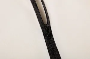 Primo piano del dettaglio della mezza zip nera sulla felpa bianca