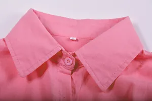 Close-up detail showing the sharp lapel collar and matching pink button of a women's shirt