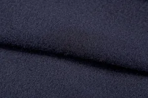 Primo piano che mostra la morbida trama del tessuto in pile blu navy della felpa invernale.