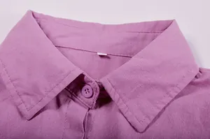 Close-up of elegant purple shirt collar showing linen fabric texture and button detail.