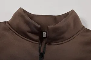 Dettaglio macro del colletto di una felpa marrone con mezza zip e tessuto strutturato