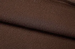 Dettaglio macro della morbida texture in pile marrone di una felpa con mezza zip da donna