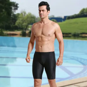 Professional men's black shark skin swim jammers shown on a fit model by the pool side