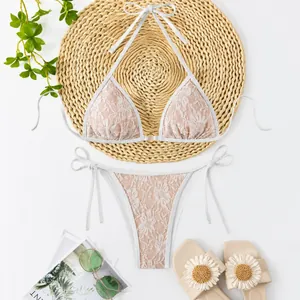 Detailansicht eines weißen Spitzen-Bikini-Sets mit nudefarbenem Futter und Bändern