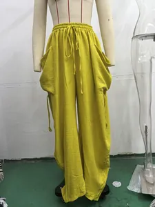 Primo piano dei pantaloni harem leggeri in lino giallo con coulisse e ampie tasche